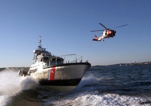 BOSTON - Two Massachusetts based Coast Guard assets, a 47-foot motor lifeboat from Station Gloucester and a Jayhawk helicopter from Air Station Cape Cod, transit out of the Gloucester Harbor during a training exercise Aug. 25. Coast Guard photo by Luke Pinneo